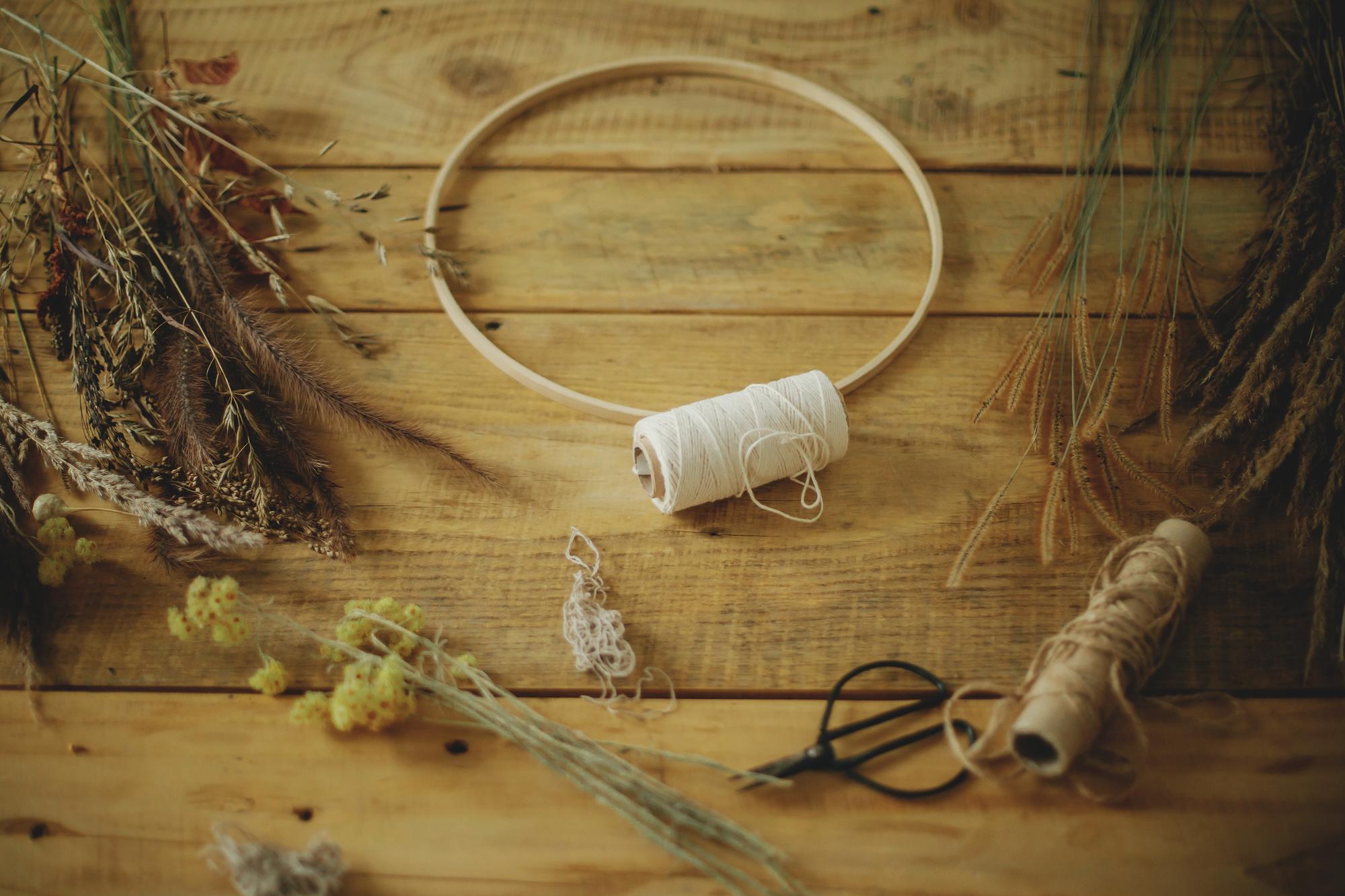 Atelierarbeitsplatz mit Stickrahmen und glänzenden Garnen